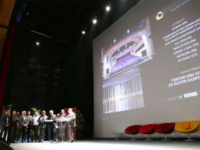 © Le Centre des Congrès de Haute-Saintonge et son architecture singulière primée L'entrée du Centre des Congrès de Haute-Saintonge lors d'un spectacle en nocturne Cérémonie des Trophées de Haute-Saintonge dans l'Auditorium Cérémonie des Journées Régionales de la Construction Bois dans l'Auditorium Cérémonie des Trophées de Haute-Saintonge dans l'Auditorium Cérémonie des 10 ans de la Maison de l'Emploi de Haute-Saintonge dans l'Auditorium Cérémonie des Journées Régionales de la Construction Bois dans l'Auditorium Concert à l'Auditorium à l'acoustique remarquable grâce au plafond en bois ondulé Concert à l'Auditorium à l'acoustique remarquable grâce au plafond en bois ondulé Concert à l'Auditorium à l'acoustique remarquable grâce au plafond en bois ondulé La cabine de traduction de l'Auditorium Le Studio TV du Centre des Congrès de Haute-Saintonge Concert à l'Auditorium à l'acoustique remarquable grâce au plafond en bois ondulé L'Agora en configuration gradins sortis L'Agora en configuration gradins sortis L'Agora en configuration gradins sortis Un concert dans l'Agora, configuration gradins sortis et parterre de danse Un concert dans l'Agora, configuration gradins sortis et parterre de danse Concert dans l'Agora Soirée cabaret dans l'Agora, gradins rétractés, tables rondes sur le parterre Thé dansant dans l'Agora, gradins rétractés, tables rondes et parterre de danse Repas dans l'Agora, gradins rétractés, tables rectangulaires Repas dans l'Agora, gradins rétractés, tables rectangulaires Mise en place pour un repas dans l'Agora avec tables rectangulaires Exposition dans le Hall d'entrée de 600m² Le Hall d'entrée de 600m² et son bar Exposition dans le Hall d'entrée de 600m² Le Hall d'entrée de 600m² Le Hall d'entrée de 600m² du haut de l'escalier monumental Le Hall d'entrée de 600m² du haut de l'escalier monumental un soir de concert Vue imprenable sur la vallée de la Seugne et la campagne haute-saintongeaise Le Hall d'entrée de 600m² en configuration repas buffet Le Hall d'entrée de 600m² en configuration repas-buffet lors d'une réunion de travail Le Hall d'entrée de 600m² en configuration repas-buffet lors d'une réunion de travail Un congressiste dans le Hall d'entrée de 600m² en configuration repas-buffet Petit déjeuner d'accueil dans le Hall d'entrée de 600m² lors d'un congrès Le bar du Hall d'entrée de 600m² Le bar du Hall d'entrée de 600m² Réunion de travail dans une des salles de séminaires Réunion de travail dans une des salles de séminaires Réunion de travail dans une des salles de séminaires Une des six salles de séminaires Une des six salles de séminaires Une des six salles de séminaires Une salle de séminaire transformée en salle d'exposition Une salle de séminaire transformée en salle d'exposition Une des sept loges Une des sept loges Une des sept loges